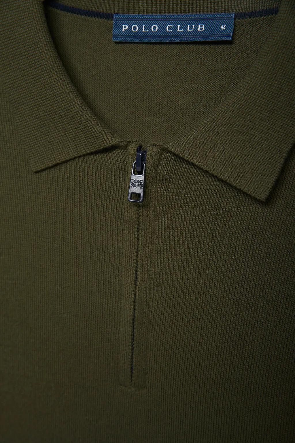 Jersey verde oliva con cuello de polo y cremallera con detalle en la manga