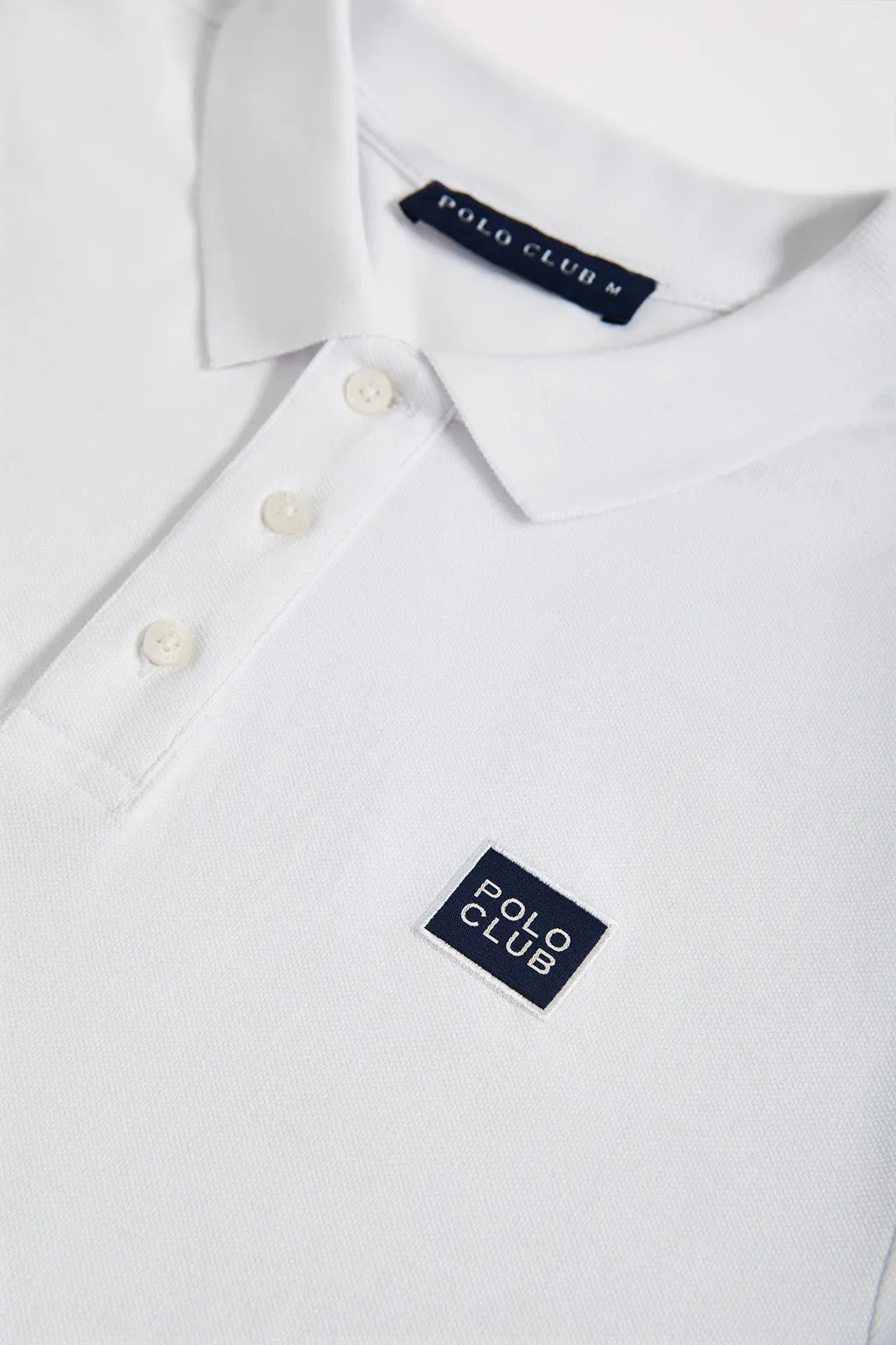 Polo blanco piqué con tapeta de tres botones y detalle Polo Club